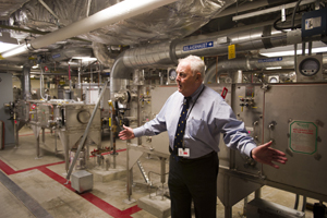 NEIDL interim director John R. Murphy in front of high tech air filtration systems atop the Biosafety Level 4 facility