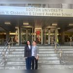 Two women on steps in front of Avedisian & Chobanian School of Medicine