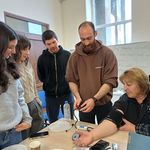 People standing around table, one woman wearing blood pressure cuff