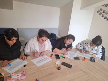 People seated at table writing during training session