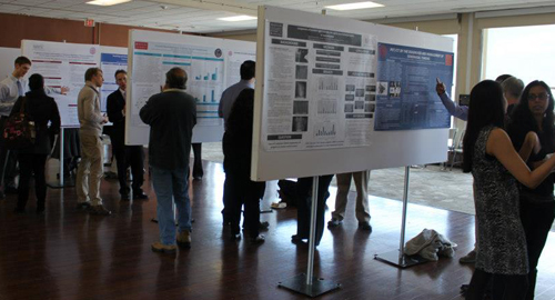 2013 Research Symposium web 1 Hiebert Lounge filled with students and posters.