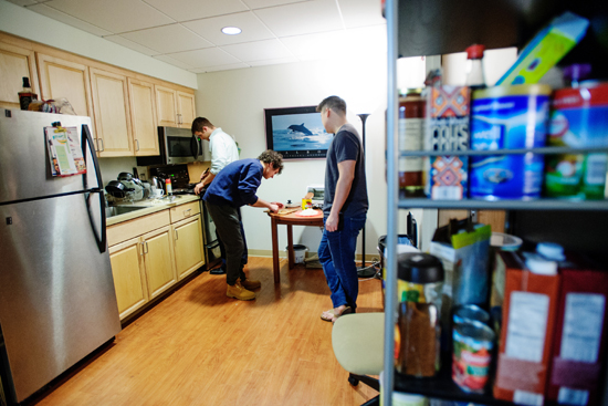 Dan McGrail (MED’16) (from left), Sam Miller (MED'17), and Fabian Chang (MED’16) prepare a meal with items purchased on a food stamp recipient's budget as part of the SNAP challenge. Photo by Jackie Ricciardi