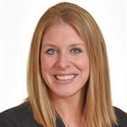 Head and shoulders of woman with shoulder-length red/blond hair smiling broadly