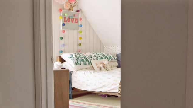 Cozy bedroom with a "LOVE" sign above bed.