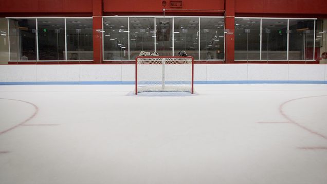 Goal net in an empty ice hockey rink.