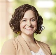Head and shoulders shot of Sarah Valentine, chin length brown wavy hair, smiling