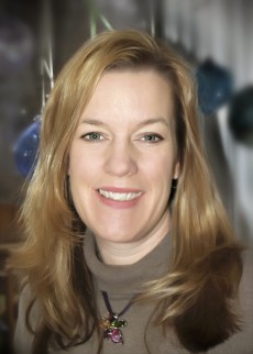 Head and shoulders shot of Tara Galovski, strawberry blond hair beyond shoulders, brownish sweater, smiling
