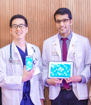 Chu and Haroon, in white coats, hold the smartphone and tablet versions respectively of the iCOUGH Recovery app