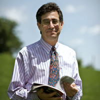 Howard Bauchner, MD outside with blue sky and greenery in background, wearing a shirt and tie