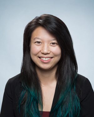 Headshot of Lena Landaverde wearing a black blazer in front of a light blue background