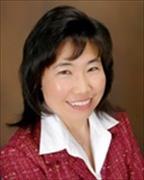 Head and shoulders of Helen Kyomen smiling wearing red jacket, white shirt