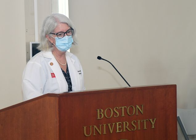 Susan White speaking at a podium