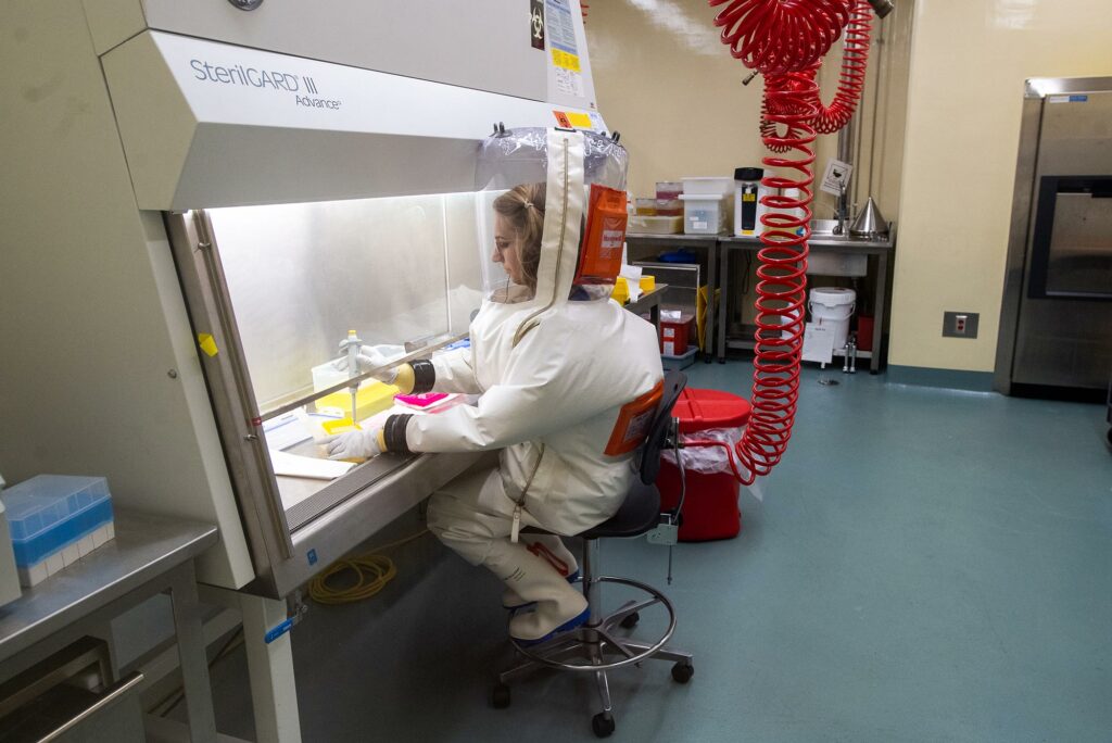 Pulmonary fellow Ellen Suder (MED’26,’26) wearing full protective gear seated at hood in the high containment lab, BSL-4, at BU’s National Emerging Infectious Diseases Laboratories (NEIDL).