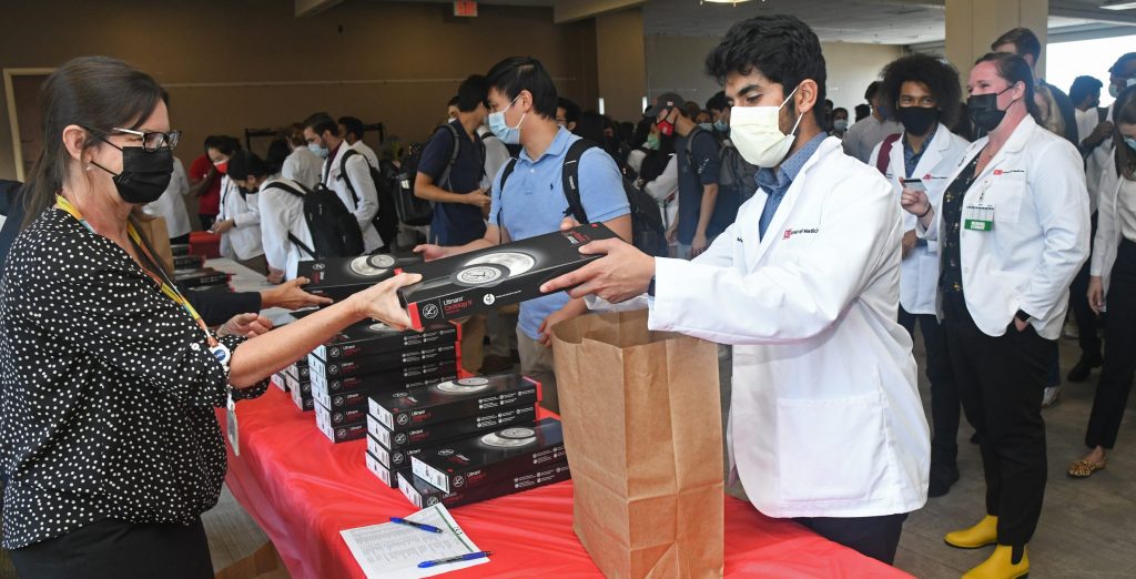 Students lined up receiving their stethoscopes in a box