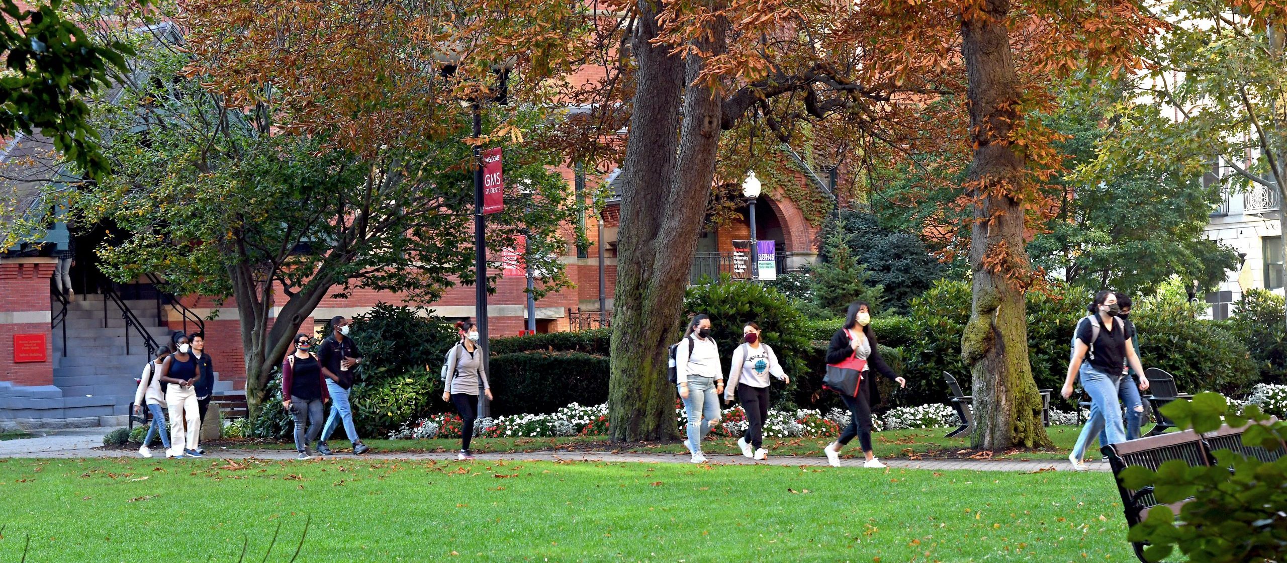 Students walking on Talbot Green wearing masks