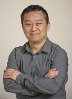 Chao Zhang standing with arms folded
