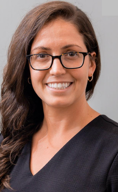 Headshot of white woman with glasses and long brown hair