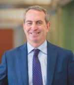 White man with a blue suit and purple tie