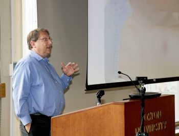 Dr. Lowe at podium speaking to the students