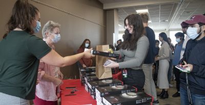 students lined up to get stethoscopes from staff