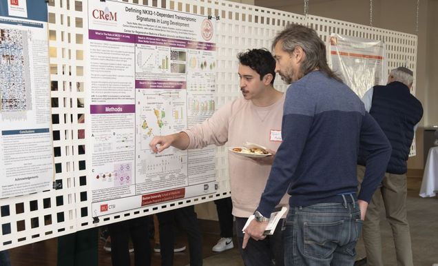 Two people in front of a poster presentation