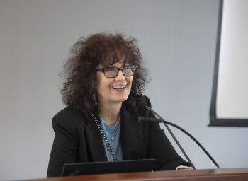 Headshot of Shelley Russek behing a podium speaking