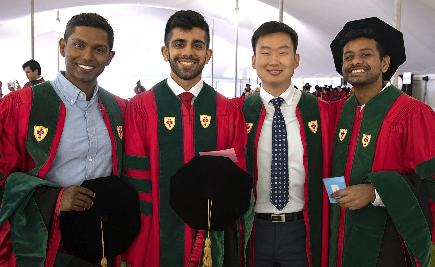 Four MD students before convocation ceremony in tent