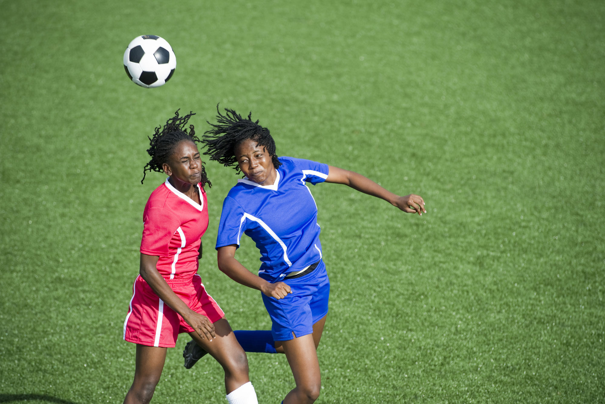 Two female soccer players competing for the ball, aerial view.