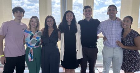 Seven STaRS participants standing in front of Hieber Lounge windows