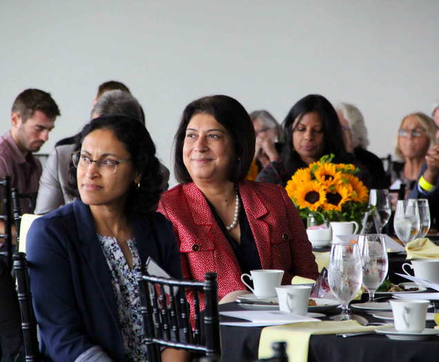 Dr. Kewalramani sitting at a table surrounded by other attendees