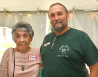 Woman and man standing under a large white function tent outdoors