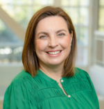 Head and shoulders image of Kathleen Swenson wearing bright green shirt, smiling broadly