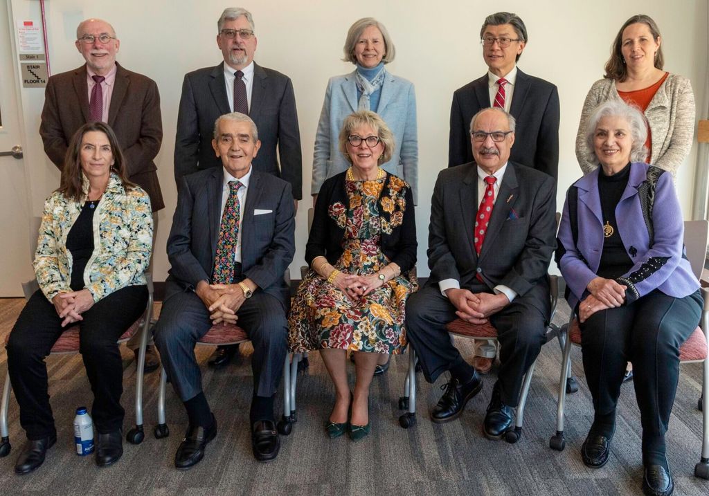 Five people seated, five people standing smiling into camera