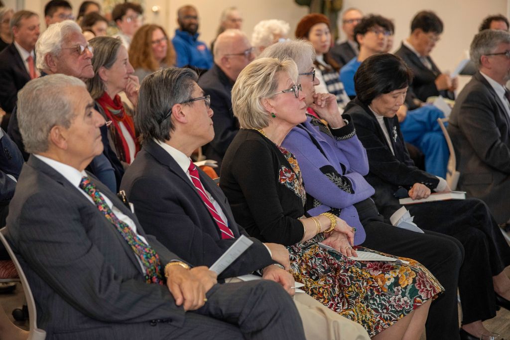 Crowd of people seated listening and watching at professorship installation