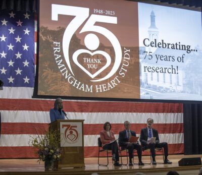 Big 75 anniversary banner with Rep. Katherine Clark speaking on stage