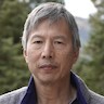 headshot of Clint Makino waring blue shirt, gray jacket, short gray hair