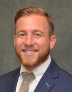 Head shot of Daniel Faden wearing blue suit