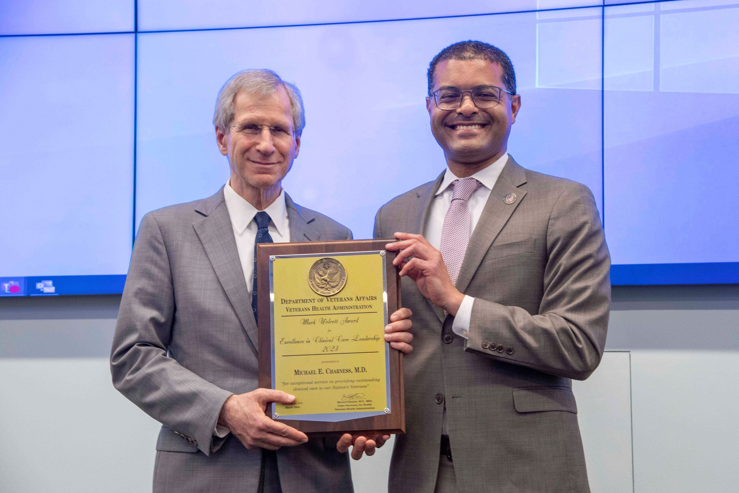 (l to r) Michael Charness receiving award plaque from Shereef Elnahal, 
