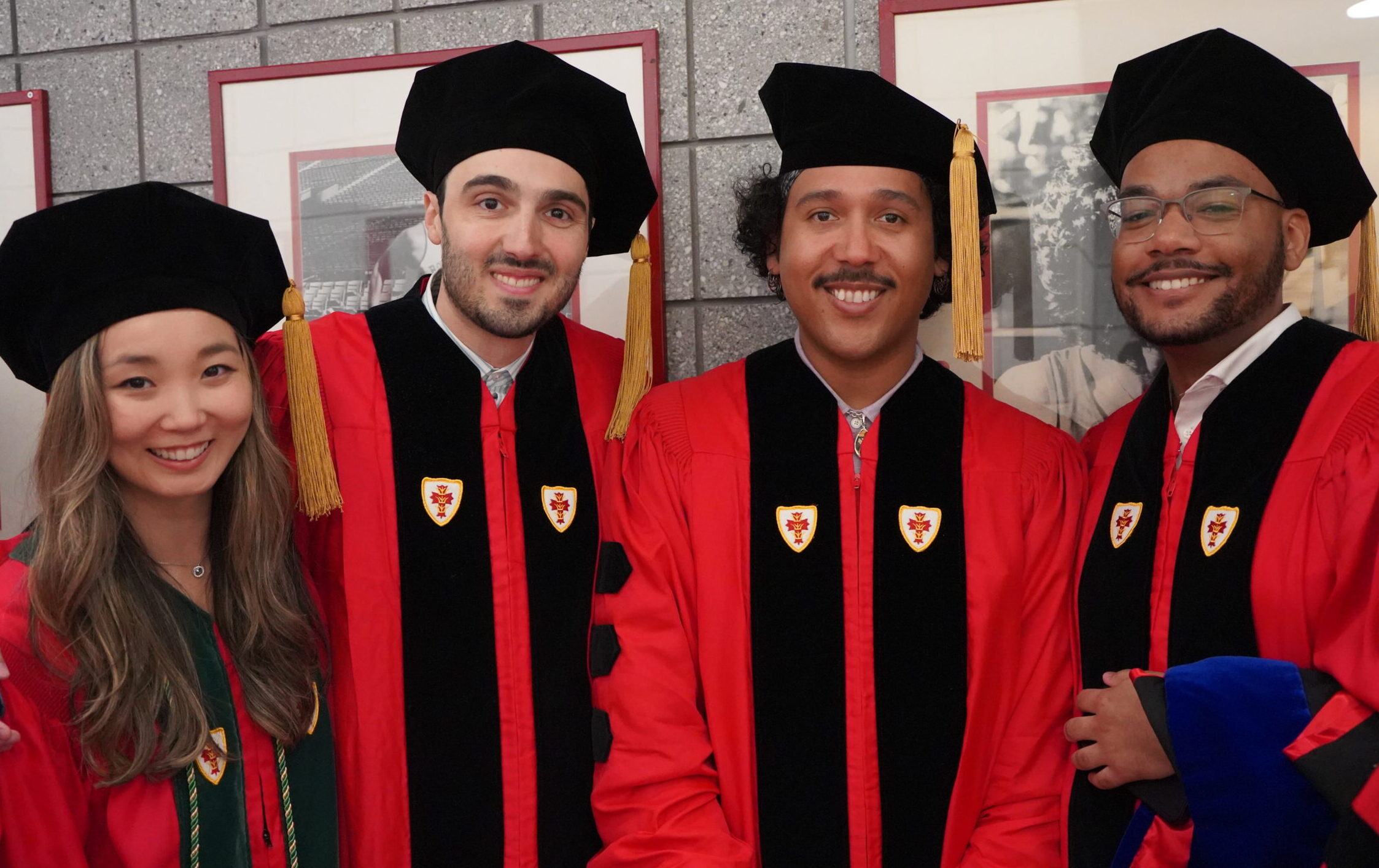 four students lined up in regalia waiting to march in