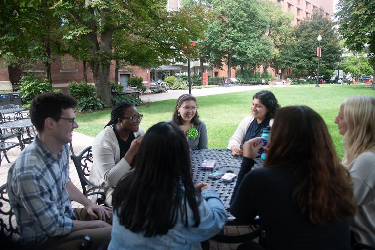 Students outside playing the card game Uno together