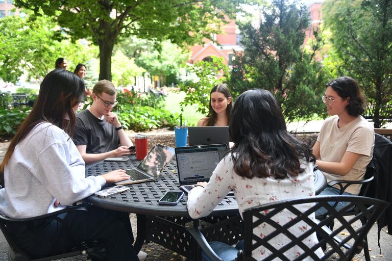 Students studying outside on their laptops