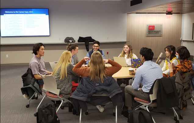 A group of people seated around a table in a conference room at BUMC for Career Expo 2023.