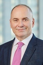 Alik Farber in dark suit, white shirt, pink tie