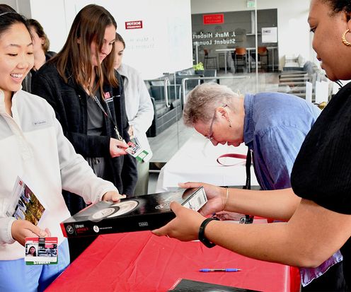 Staff member handing new stethoscope to a student
