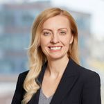 Head and shoulders of Heather Edwards, long blond wavy hair, dark suit jacket, smiling broadly