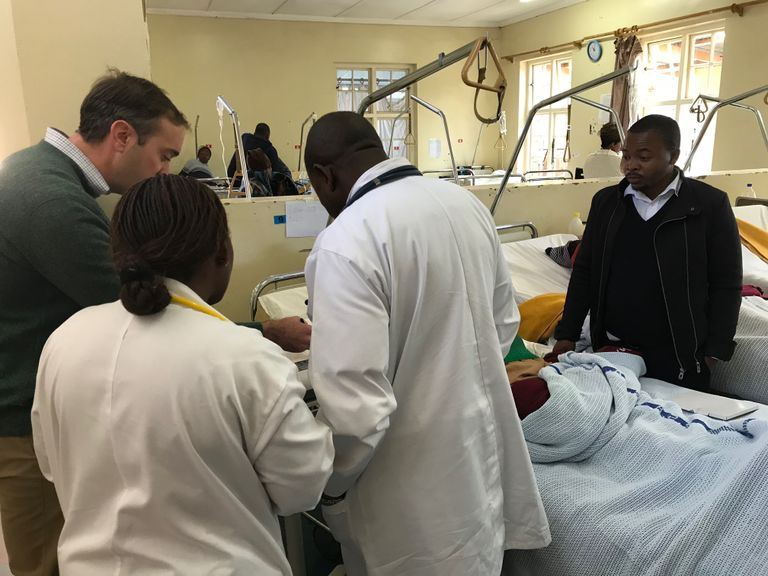 Medical professionals around a patient in a hospital ward. a