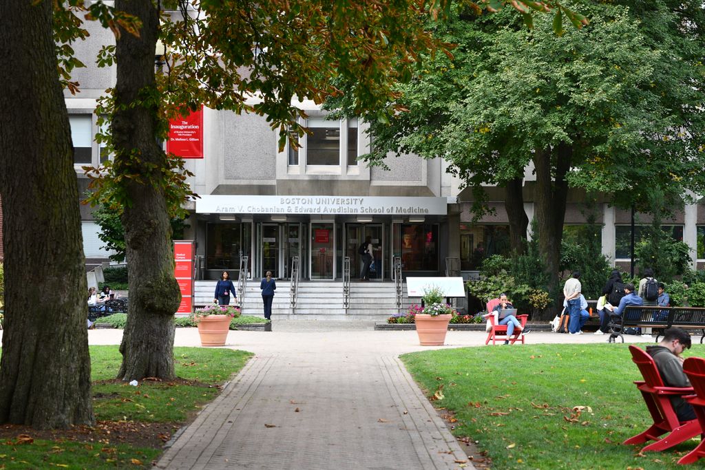 People walking around and sitting near the entrance of Boston University Aram V. Chobanian & Edward Avedisian School of Medicine.