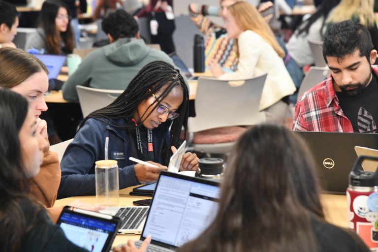 Groups of people at tables studying.