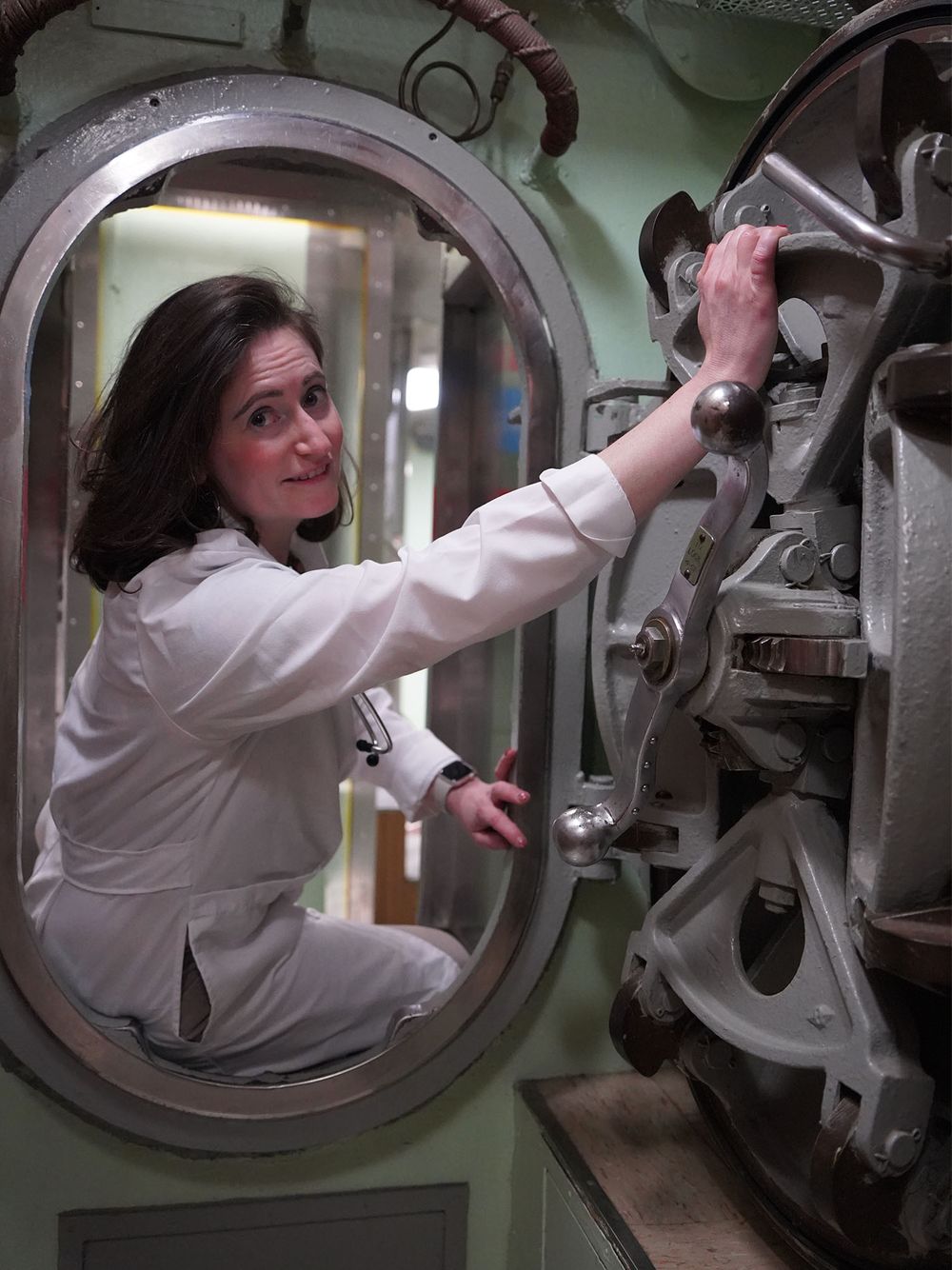 Photo of Adrienne Parad, MD’07 seated in submarine hatchway