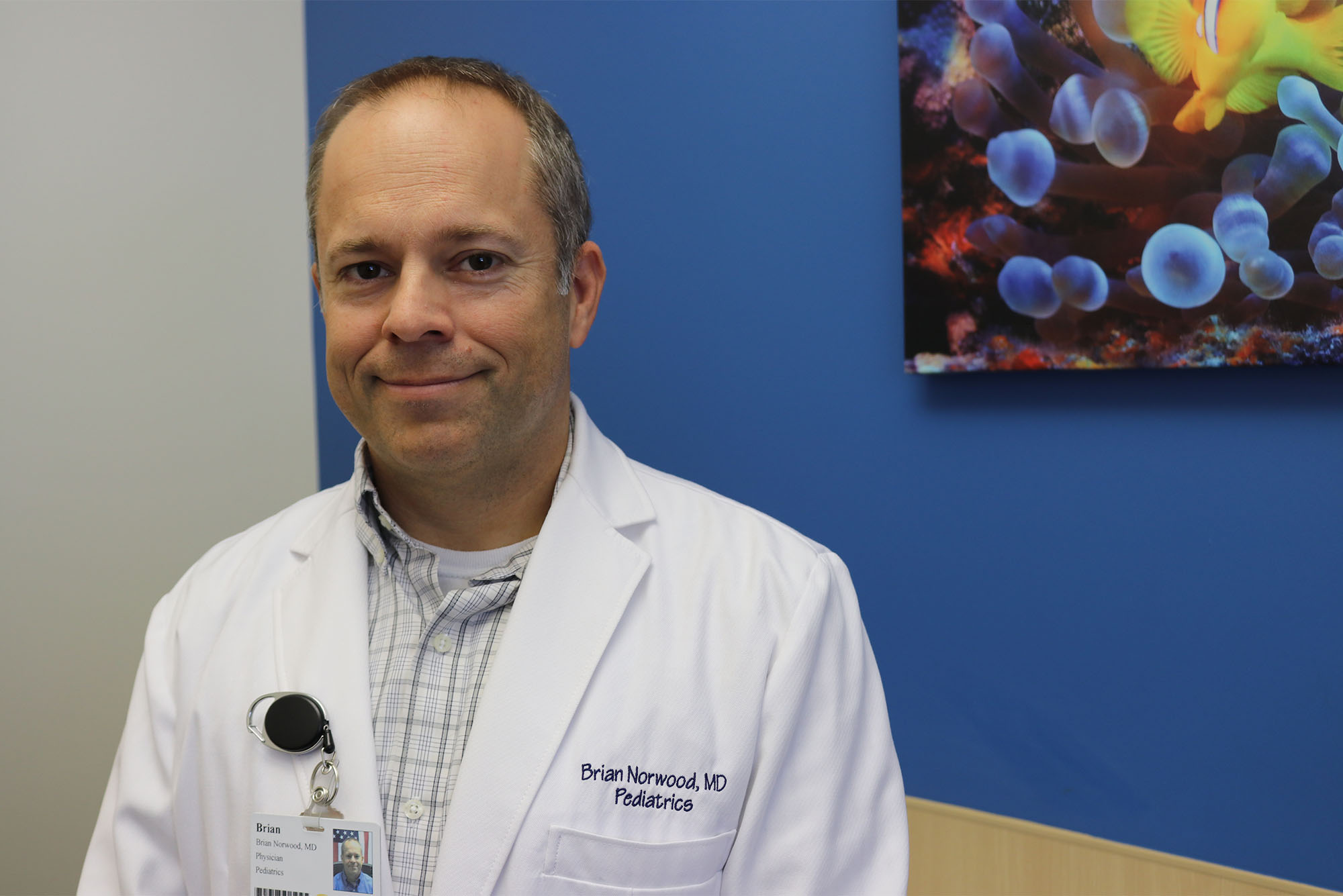 Photo of retired Navy Captain Brian Norwood, MD ’03 in his white coat